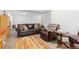 Spacious living room features a leather sofa, armchair, wooden coffee table, and neutral decor at 11033 Olathe St, Commerce City, CO 80022