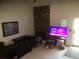 Living room featuring decorative stone fireplace, television and front door at 1511 Belero St, Broomfield, CO 80020