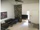 Bright living room with a stone fireplace, TV, and neutral-colored carpet at 1511 Belero St, Broomfield, CO 80020
