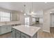 Open kitchen with grey cabinets, stainless steel appliances, an island, pendant lighting, and wood floors at 1866 Sawtooth Mountain Dr, Berthoud, CO 80513