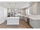 Stylish kitchen with grey cabinets, stainless steel appliances, pendant lights, island, and wood floors at 1866 Sawtooth Mountain Dr, Berthoud, CO 80513
