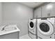 This well-lit laundry room features a washer, dryer, and sink for convenience at 1866 Sawtooth Mountain Dr, Berthoud, CO 80513