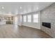 Spacious living room featuring wood floors, a modern fireplace, large windows, and an open concept layout at 1866 Sawtooth Mountain Dr, Berthoud, CO 80513
