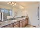 Elegant bathroom featuring dual sinks, granite counters, and a glass-enclosed shower at 90 Pipit Lake Way, Erie, CO 80516