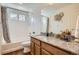 Bright bathroom with a tub and shower, granite countertop, wood cabinets, and tile backsplash at 90 Pipit Lake Way, Erie, CO 80516