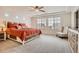 Spacious primary bedroom with a tray ceiling, large windows, and plush carpeting at 90 Pipit Lake Way, Erie, CO 80516