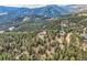 Scenic aerial shot of a home nestled within a dense forest, showcasing its serene and private location at 135 Poorman Rd Rd, Boulder, CO 80302