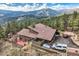 Sweeping aerial view of a gorgeous mountain home with an expansive deck and driveway at 135 Poorman Rd Rd, Boulder, CO 80302
