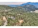 Expansive aerial view of a mountain home nestled in lush greenery with mountain views at 135 Poorman Rd Rd, Boulder, CO 80302