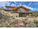 Exterior of home with brick pathway, native vegetation, and a terraced yard at 135 Poorman Rd Rd, Boulder, CO 80302