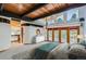 This main bedroom features vaulted wood ceilings, large windows, exterior deck, and partial kitchen view at 135 Poorman Rd Rd, Boulder, CO 80302