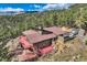 Mountain home featuring an expansive deck, mature trees, and a private driveway at 135 Poorman Rd Rd, Boulder, CO 80302