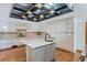Bright kitchen boasts sleek white cabinets, marble countertops and backsplash, hardwood floors, and creative grid lighting at 135 Poorman Rd Rd, Boulder, CO 80302