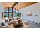 Bright living room featuring a wall of windows with wooded views, complemented by neutral décor and wood ceilings at 135 Poorman Rd Rd, Boulder, CO 80302