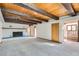 Spacious living room with wood ceiling beams, painted brick fireplace, and carpet flooring at 135 Poorman Rd Rd, Boulder, CO 80302