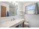 Updated bathroom with new marble vanity, white cabinetry, and tiled shower and window at 8653 Red Clover Ct, Parker, CO 80134