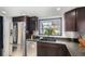 Well-equipped kitchen with stainless steel appliances, granite countertops, and dark wood cabinetry at 8653 Red Clover Ct, Parker, CO 80134
