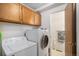 Well-lit laundry room includes modern washer and dryer with overhead cabinets for storage at 8653 Red Clover Ct, Parker, CO 80134