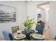 Cozy dining room with glass table, blue upholstered chairs, and stylish decor leading to modern kitchen at 14000 Winding River Ct # T3, Broomfield, CO 80023