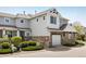 Beautiful townhome displaying stone accents, a garage, a well-maintained landscape, and neutral gray siding at 14000 Winding River Ct # T3, Broomfield, CO 80023