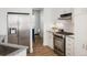 Modern kitchen featuring stainless steel refrigerator, white cabinets and backsplash with stainless steel oven at 14000 Winding River Ct # T3, Broomfield, CO 80023