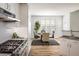 Bright kitchen with stainless steel appliances, white cabinets, and hardwood floors leading into the dining area at 14000 Winding River Ct # T3, Broomfield, CO 80023