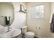 Stylish powder room with a modern sink, oval mirror, shelf decor, and a bright window at 14000 Winding River Ct # T3, Broomfield, CO 80023