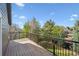 View from wooden balcony with black railing, overlooking mature trees and backyard at 9714 Chanteclair Cir, Highlands Ranch, CO 80126