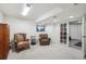 Basement with two comfortable wingback chairs, soft carpet and glass-paned French doors to a basement home gym at 9714 Chanteclair Cir, Highlands Ranch, CO 80126