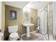 Bathroom features a pedestal sink, walk-in shower with glass doors, and decoratively painted walls at 9714 Chanteclair Cir, Highlands Ranch, CO 80126