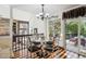 Charming dining area with a glass table, chandelier, and sliding glass doors leading to the patio at 9714 Chanteclair Cir, Highlands Ranch, CO 80126
