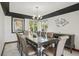 Elegant dining room featuring a modern chandelier, dark wood accents, and large windows offering natural light and views at 9714 Chanteclair Cir, Highlands Ranch, CO 80126
