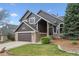 Lovely two-story home showcasing a green lawn, stone detailing, an attached garage, and charming architectural features at 9714 Chanteclair Cir, Highlands Ranch, CO 80126