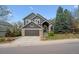 Inviting two-story home with a well-maintained lawn, stone accents, and an attached garage, set against a clear blue sky at 9714 Chanteclair Cir, Highlands Ranch, CO 80126