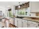 Bright kitchen with white cabinets, granite countertops, and a large window overlooking the backyard at 9714 Chanteclair Cir, Highlands Ranch, CO 80126