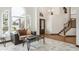Bright living room with large arched windows, tile floors, and a modern coffee table, creating an inviting atmosphere at 9714 Chanteclair Cir, Highlands Ranch, CO 80126