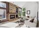 Inviting living room with a stone fireplace, vaulted ceilings, and large windows showcasing the outdoor view at 9714 Chanteclair Cir, Highlands Ranch, CO 80126