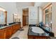 Luxurious bathroom with dual vanities, a soaking tub, granite countertops, and natural wood accents near bright window at 378 Juniata Cir, Breckenridge, CO 80424