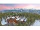 Breathtaking log home with mountain views, nestled among lush trees and capped with snow, at sunset at 378 Juniata Cir, Breckenridge, CO 80424