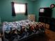 A cozy bedroom features vibrant blue walls and a decorative quilt on the bed at 1165 Milky Way, Thornton, CO 80260