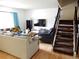 Open-concept living room with hardwood floors, staircase, and ample seating, perfect for entertaining at 1165 Milky Way, Thornton, CO 80260