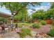 Landscaped backyard featuring a covered patio, mature trees, flowerbeds, and a manicured lawn at 40 S 34Th St, Boulder, CO 80305