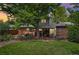 Grassy backyard with a covered patio area, landscaping, and large trees for shade at 40 S 34Th St, Boulder, CO 80305
