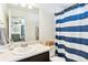Bright bathroom featuring a shower with blue striped curtain at 20017 E 48Th Pl, Denver, CO 80249