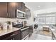 Modern kitchen with stainless steel appliances and granite countertops flows into a bright living area at 20017 E 48Th Pl, Denver, CO 80249