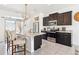 Modern kitchen featuring dark wood cabinets, stainless steel appliances, and granite countertops, island seating at 20017 E 48Th Pl, Denver, CO 80249