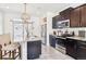 Stylish kitchen featuring granite counters, island seating, stainless steel appliances, and dark wood cabinetry at 20017 E 48Th Pl, Denver, CO 80249