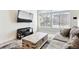 Bright living area featuring a large sectional, modern TV, and big windows that fill the room with light at 20017 E 48Th Pl, Denver, CO 80249