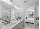 Bathroom featuring double sinks, gray cabinets, white countertops, and glass-enclosed shower at 2078 S Holly St # 3, Denver, CO 80222
