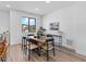 Dining room with wood table and modern chairs, bright with view out of large window at 2078 S Holly St # 3, Denver, CO 80222